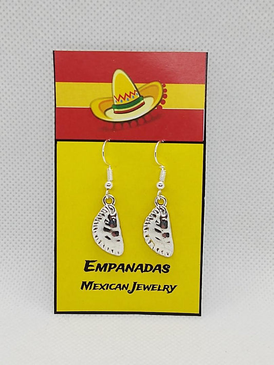 Silver Mexican empanada earrings hanging on a yellow and red card with sombrero design
