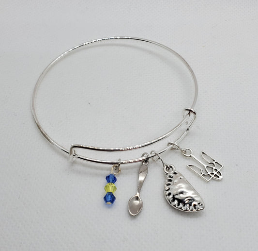 Silver Ukrainian charm bracelet with blue and yellow beads, spoon, pierogi, and trident charms