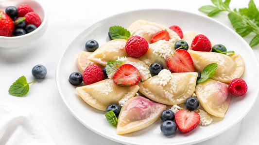 Plate of delicious summer pierogi garnished with fresh berries and herbs